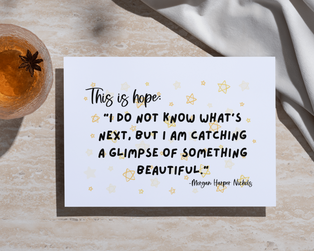 Motivational quote card on a textured surface with a glass of tea.